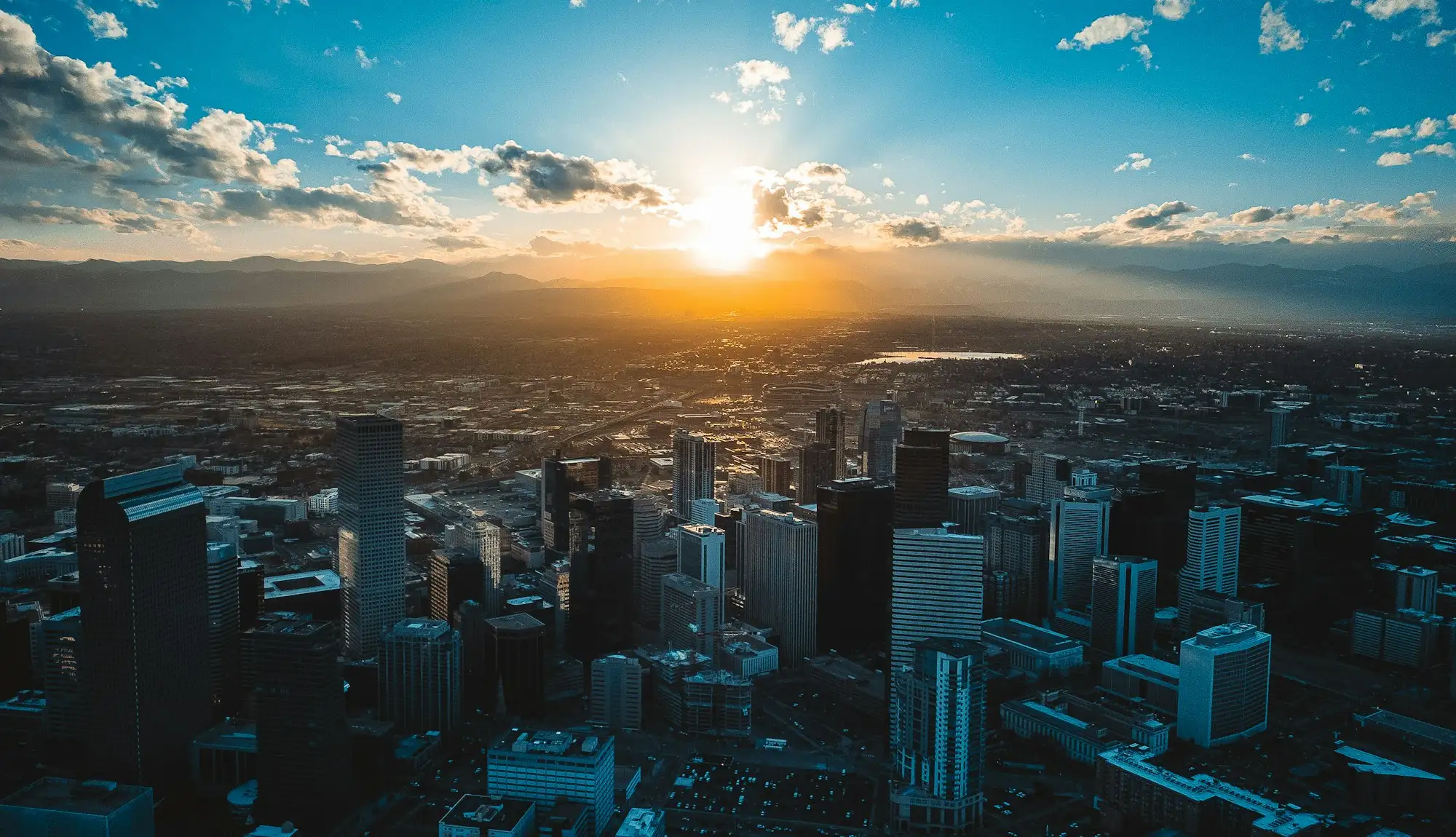 Downtown Denver at sunset, with the Rocky Mountains on the horizon