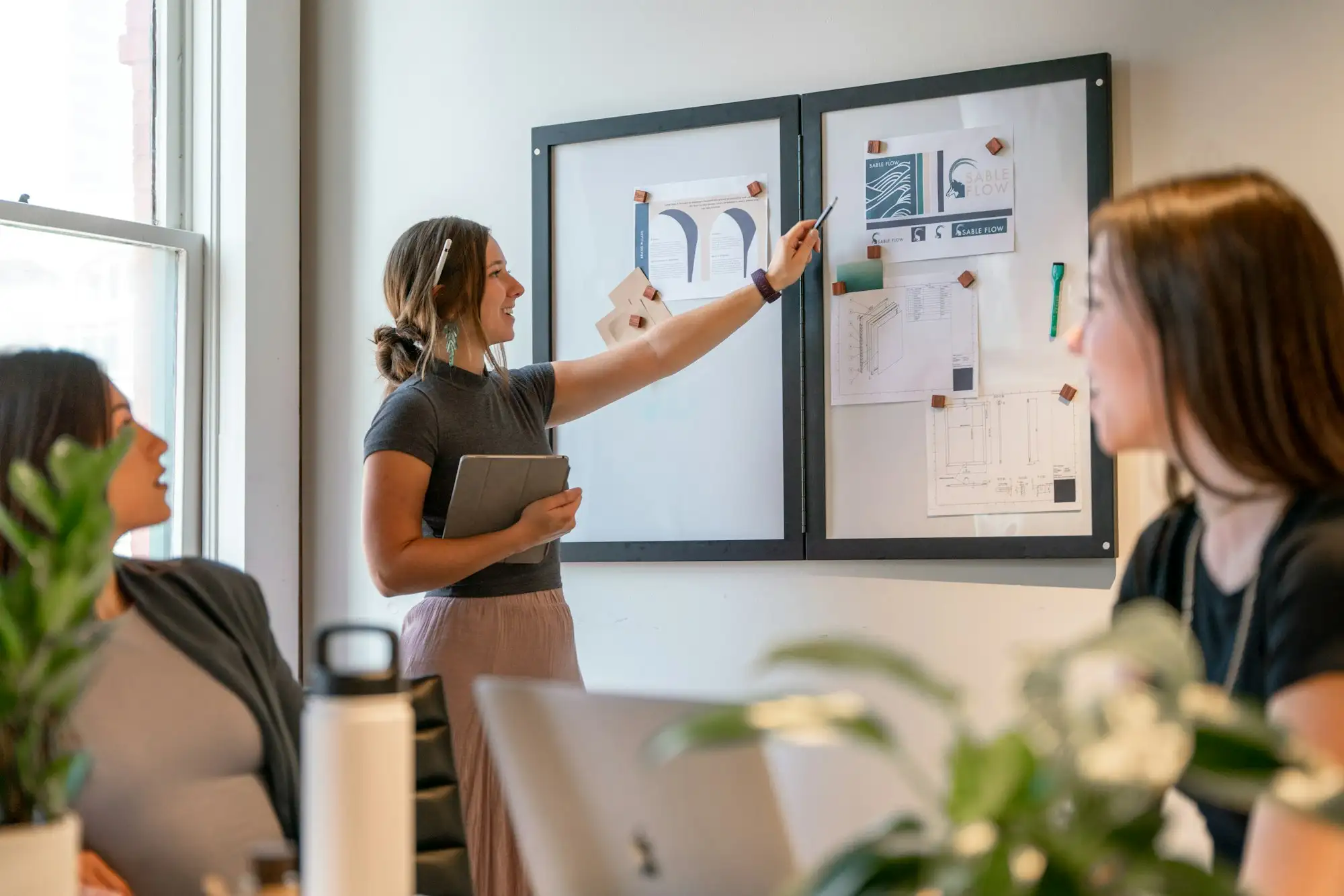 Colleagues planning a project together in front of a board covered in notes